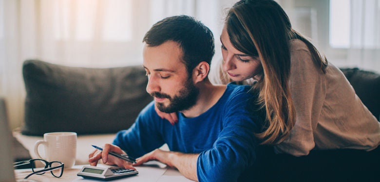 Couple using calculator and thinking about debt consolidation